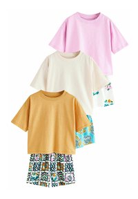 Trzy t-shirty z krótkim rękawem: różowy, kremowy i musztardowy. T-shirty są miękkie, bawełniane i mają luźny krój. Musztardowa koszulka dobrze komponuje się ze wzorzystymi szortami.