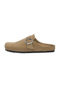 Barna velúr slip-on klumpa állítható fémbütyök, texturált felsőrész, lekerekített orr és bordázott fekete gumitalp jellemzi.