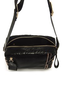 Borsa a spalla nera in nylon con texture imbottita, zip dorata e motivo a righe. Presenta una tracolla removibile e un piccolo zip pull.