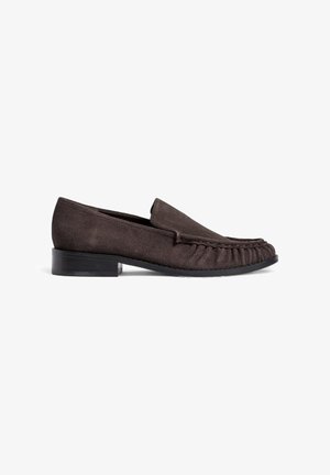 Rjavi nubuk loafers s nizkim črnim peto in zgrabljenimi detajli spredaj. Gladka tekstura, zaobljen toe in minimalističen dizajn.
