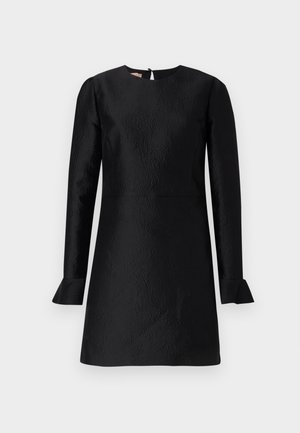 Schwarzes Kleid mit langen Ärmeln, strukturiertem Muster, Rundhalsausschnitt und ausgestellt geschnittenen Bündchen. Hat einen Abschluss mit Schlüsselöffnung auf der Rückseite.