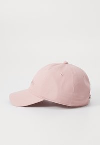 Gorro de tela rosa claro, con visera curva, diseño de seis paneles y logo bordado en la parte frontal. Textura suave y estilo casual.