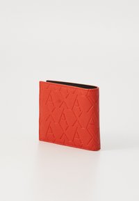 Red textured wallet featuring embossed geometric patterns, bi-fold design, and black interior. Smooth outer material with durable stitching.