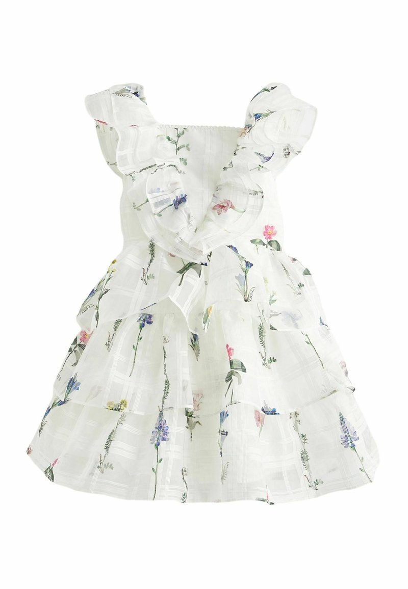 Robe blanche sans manches avec des épaules volantées et une jupe à étages, décorée d'un motif de délicates fleurs sauvages et de verdure.