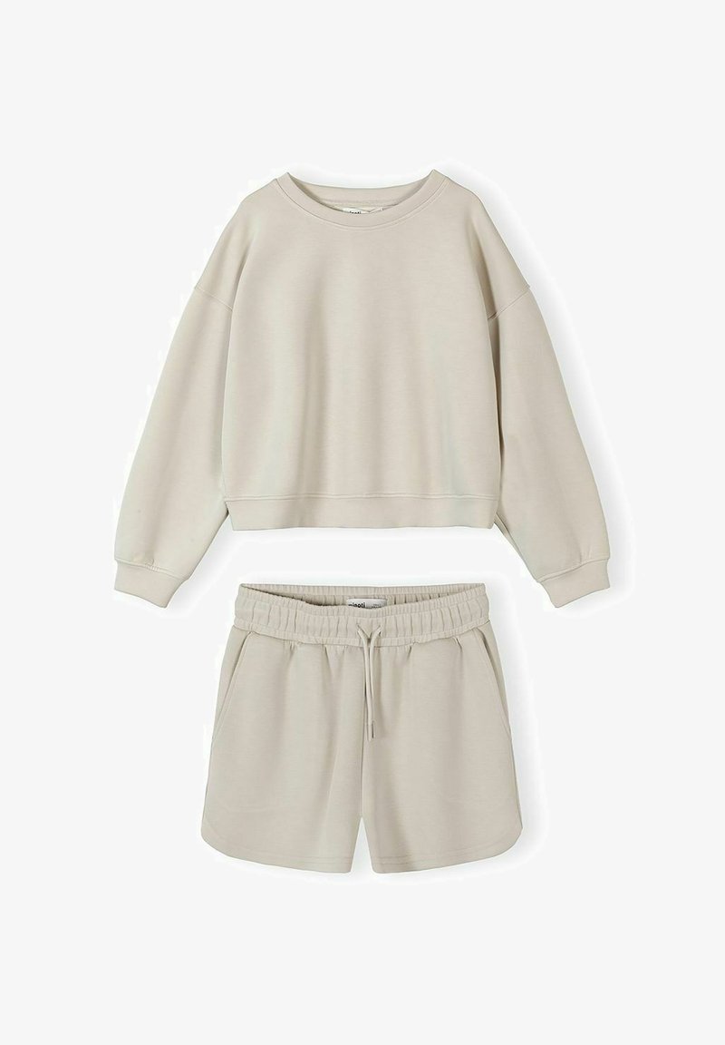 Ensemble lounge beige deux pièces avec sweat-shirt à col rond à manches longues et short à taille élastique avec cordon de serrage sur fond blanc.