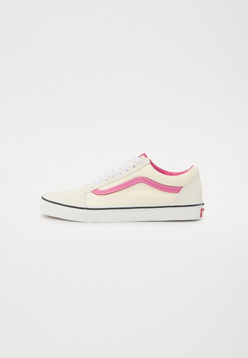 Creme farvet ruskindssneaker med pink detaljer og hvide snørebånd. Har en sort gummiydersål og en polstret krave for komfort.