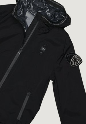 Černá bundu s kapucí, předním zipem, zipovanou boční kapsou a vyšívanou nášivkou ve tvaru štítu na horní části rukávu.