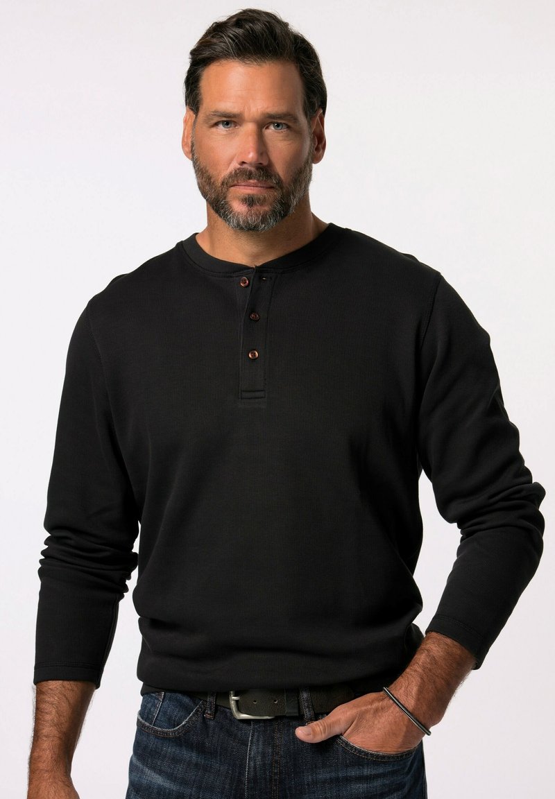 Schwarz long-sleeve Henley-Shirt mit drei braunen Knöpfen am Kragen, aus strukturiertem Stoff, kombiniert mit blauen Jeans und einem schwarzen Gürtel.