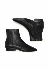 Botas de cuero negro hasta el tobillo con punta afilada, tacón bajo cuadrado y detalle de cremallera en el lateral. Textura suave y diseño minimalista.