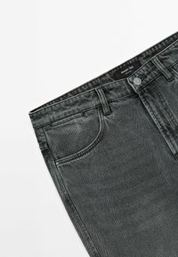 Dark gray denim jeans with a classic five-pocket design, button closure, and slight fading texture. Brand label visible at the waistband.