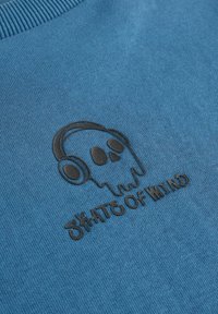 Blå bomulds sweatshirt med et sort prægede kranium med hovedtelefoner design og teksten "SKATE OF MIND" under.
