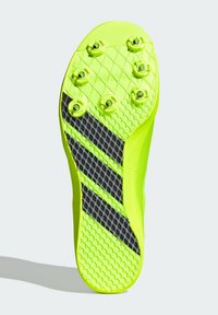 Suola di scarpa sportiva gialla brillante con accenti neri, caratterizzata da un motivo antiscivolo testurizzato e sei tacchetti rimovibili per una migliore trazione.