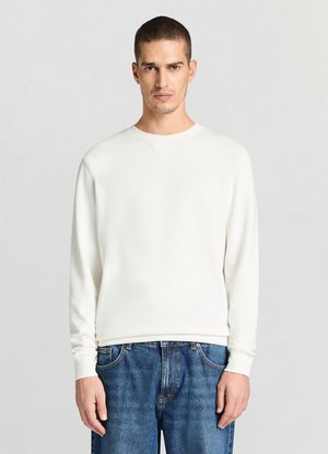 Weißes Sweatshirt mit langen Ärmeln, rundem Ausschnitt, gerippten Bündchen und leicht strukturierter Stoff, kombiniert mit blauen Denim-Jeans.