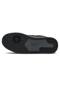 Semelle de chaussure en caoutchouc noir présentant un design à motifs avec des textures circulaires et striées. Comprend un logo central et des accents circulaires en relief.
