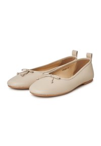 Ballerine in pelle beige con punte arrotondate, fiocchetti decorativi sul davanti e piccole asole sul retro. Suola in gomma piatta.