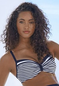 Modra in bela bikinijeva zgornja del z zvitim sprednjim dizajnom in nastavljivimi naramnicami. Material se zdi gladek in raztegljiv.