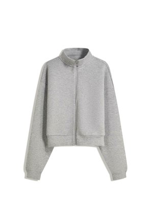 Kratka siva zip-up kapuca s visokim ovratnikom, dugim rukavima i rebrastim manžetama. Izrađena od mekog, laganog materijala s glatkom teksturom.