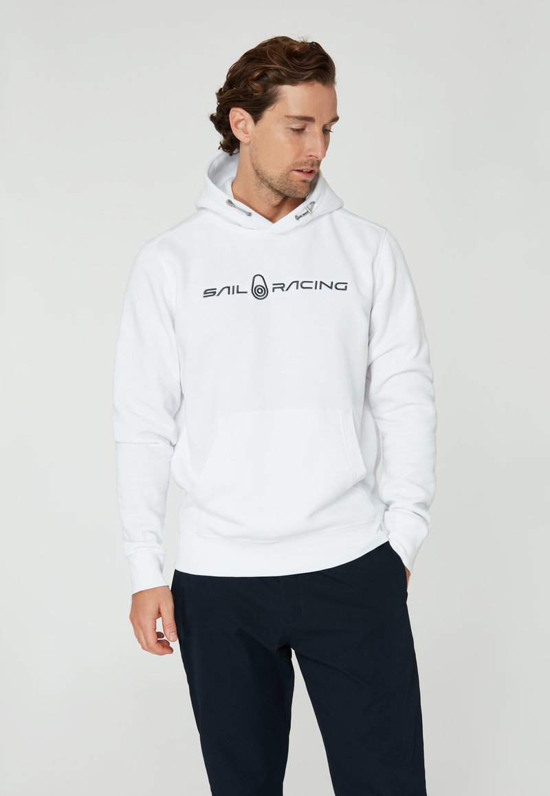Sudadera blanca con el logotipo "SAIL RACING" en negro. Cuenta con un bolsillo frontal, capucha con cordón y puños y dobladillo acanalados. Textura de tela suave.