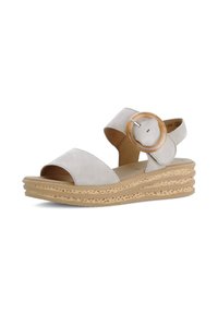 Beige suède wedge sandalen met twee brede banden, een grote ronde gesp en een gelaagde platformzool met uitsnijdingen.