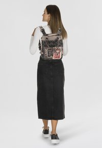 Rucksack mit gestepptem Design, in zartem Rosa und grafischen Mustern; verstellbare Träger; passende schwarze Akzente.
