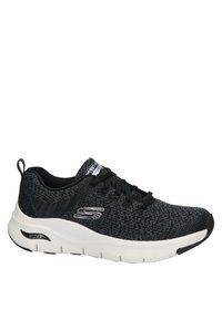 Chaussure de sport tricotée noire avec une semelle intermédiaire blanche, tige en tissu texturé, design à lacets et détail en logo argenté sur le côté.