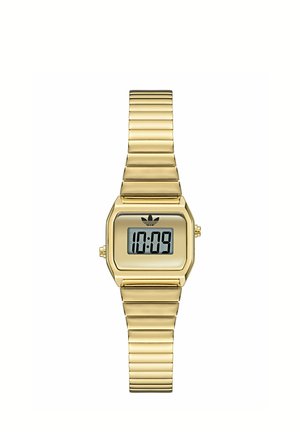 Montre digitale dorée avec bracelet métallique extensible affichant l'heure 10:09 et un logo Adidas noir au-dessus de l'écran.