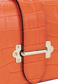 Orange faux croc lædertaske med rektangulær form, der har en guldfarvet metallås og kontrasterende sort syninger.