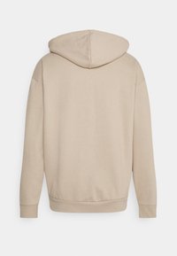 Beige hoodie med en mjuk textur, med en rund huva, sänkta axlar och ribbade muddar och nederkant för en avslappnad passform.