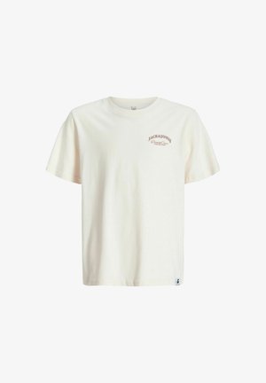 Lys beige bomulds-T-shirt med "Jack & Jones" logo, parret med sorte løse bukser og beige sko, suppleret med en pink kasket.