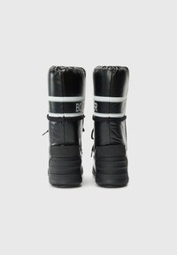 Zwarte winterlaarzen met een glanzende afwerking, ronde toppen, elastische boorden en witte strepen met de merknaam. Gekartelde rubberen zolen voor grip.
