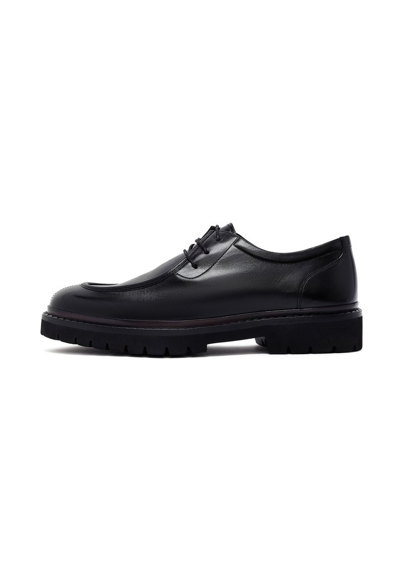 Zwarte leren schoen met een ronde teen, vetersluiting aan de voorkant en een chunky zool. Glad textuur met subtiele stiksels en een dikke loopvlak.