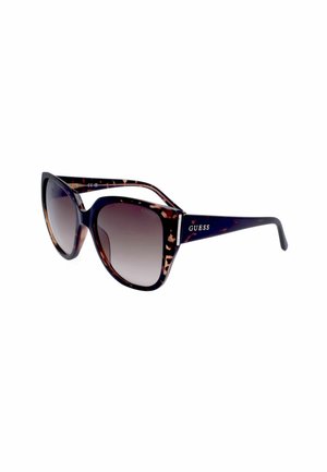 Occhiali da sole stile cat-eye tartarugati con lenti sfumate scure e logo "GUESS" sulle aste.