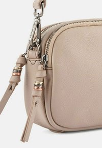 Borsa a tracolla in pelle beige chiaro. Caratterizzata da una finitura testurizzata, hardware in argento, due dettagli intrecciati sulle zip e una base piatta.