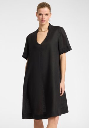 Black linen dress with short sleeves, V-neckline, and side pockets. Features a loose fit and subtle texture.