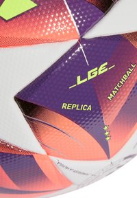 Voetbal met een textured witte en paarse oppervlakte, voorzien van oranje accenten en gedurfde zwarte geometrische patronen. Labels met de teksten "LGE," "REPLICA," en "MATCHBALL."