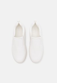Sapatilhas brancas tipo slip-on feitas de material sintético liso, com ponta arredondada, painéis laterais elásticos e design minimalista.