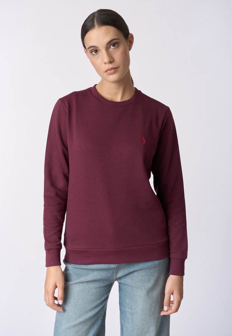 Felpa bordeaux in cotone, con scollatura a girocollo, maniche lunghe e un piccolo logo ricamato sul petto. Texture liscia.