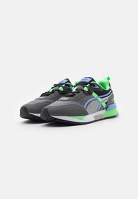 Black and gray athletic sneakers with blue and green accents, textured mesh upper, padded collar, and rubber sole. Laced design.