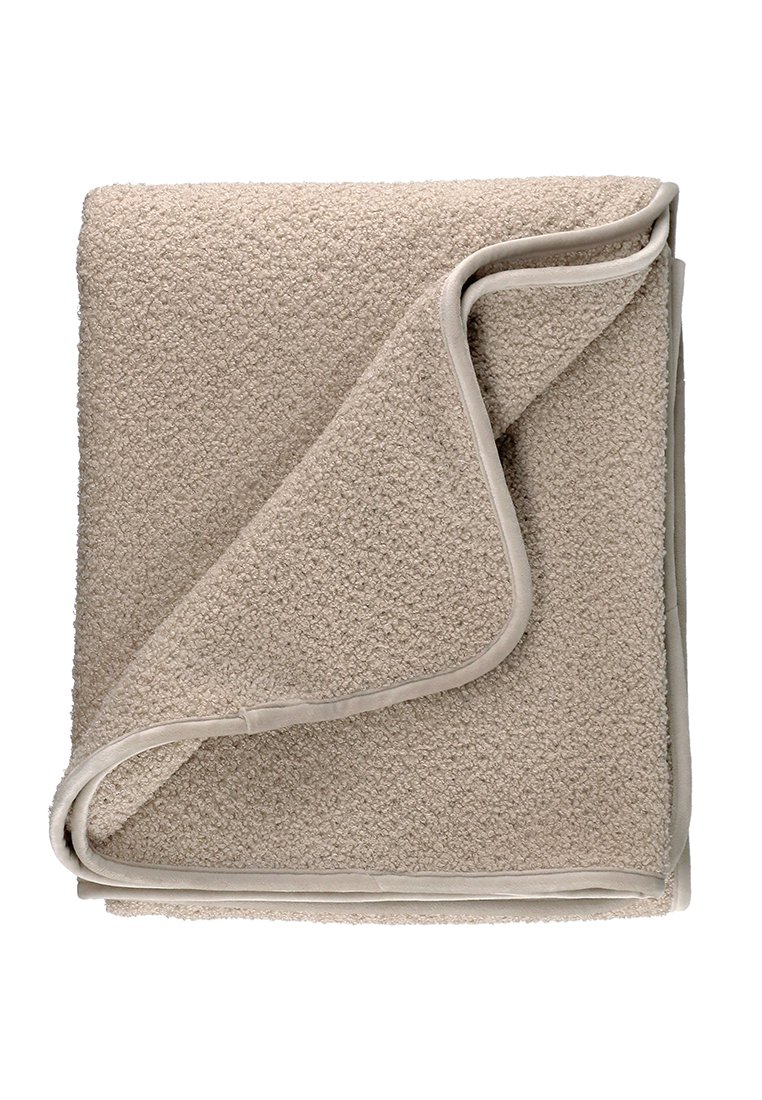 Beige fleecedeken met een gestructureerd oppervlak en een gladde, tan rand. De deken is gevouwen, wat een zachte, gezellige uitstraling geeft.