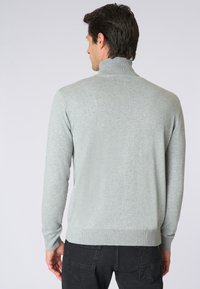 Maglione a collo alto grigio chiaro, a maniche lunghe, realizzato in materiale morbido, con un design aderente e polsini e orlo a coste.