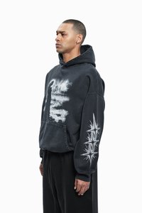 Black hoodie with white graphic print and starburst design on sleeve, featuring a kangaroo pocket and ribbed cuffs, made from soft fabric.