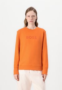 Oranžová mikina s okrúhlym výstrihom a dlhými rukávmi. Obsahuje tonálny logo "BOSS" na hrudi. Vyrobená z mäkkého materiálu.