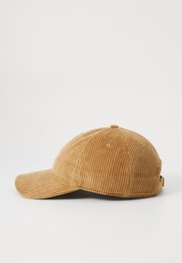 Cappellino da baseball in corduroy color cammello con cintura regolabile, mostrato di lato su uno sfondo bianco.