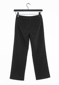 Czarne spodnie w paski z szerokimi nogawkami. Posiadają wysoki stan i dwie boczne kieszenie. Wiszą na czarnym wieszaku.