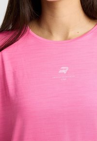 Camiseta atlética de manga corta en color rosa con cuello redondo. Presenta una textura sutil y un logo blanco con "SWEDISH SPORTSWEAR" debajo.