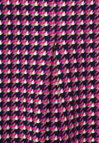Kangaskangasta löytyy geometrinen houndstooth-kuvio vaaleanpunaisena, valkoisena ja beigenä tummansinisellä taustalla, ja sen pinta on sileä.