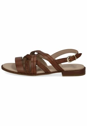 Brown leather sandal with braided straps, flat sole, and adjustable ankle buckle. Features minimalistic design and textured detailing on straps.