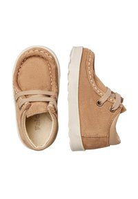 Scarpe in suede color beige per bambini, di dimensioni per neonati, con cuciture bianche, lacci beige e suole in gomma bianca, mostrate da angolazioni frontali e laterali.