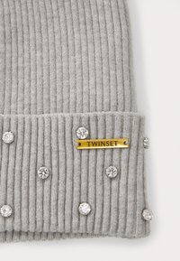 Graue gerippte Strickmütze mit silbernen Strasssteinen und einem goldenen "TWINTSET"-Aufnäher am Bündchen. Weiche Textur und enganliegendes Design.