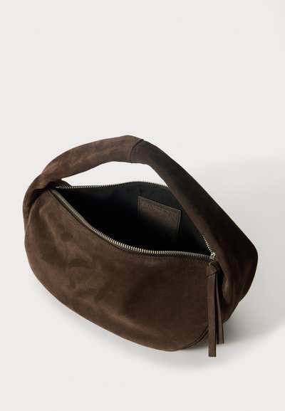 Καφέ σουέτ τσάντα χειρός σε στρογγυλό σχήμα, με κλείσιμο φερμουάρ και κοντό χερούλι. Το εσωτερικό είναι επενδεδυμένο με μαύρο υλικό.